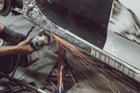 A man sawing through a piece of metal