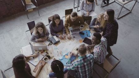 A group of young people sitting around a table discussing a project