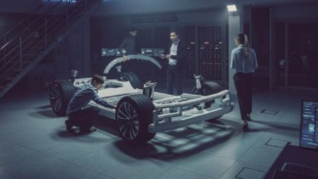 Group of people assembling the model of a car