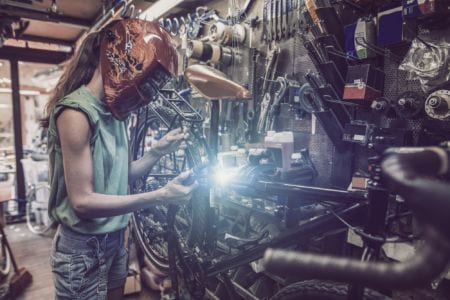 A woman welding a bike