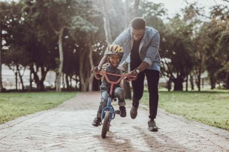 A man teaching a child to ride a bike