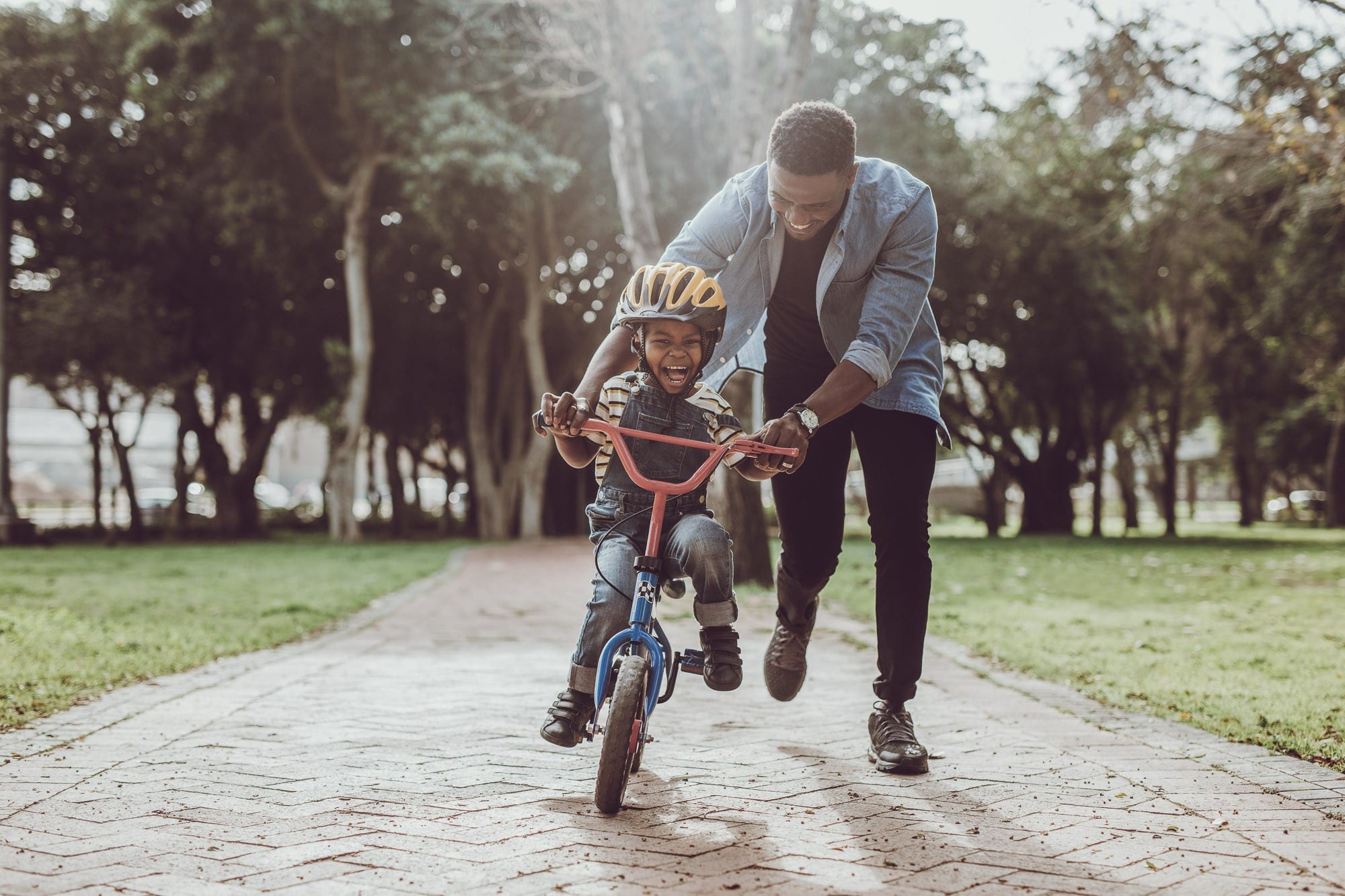 A man teaching a child to ride a bike
