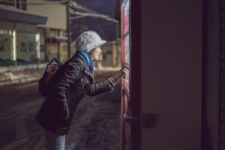 A woman knocking on a door in a dark street