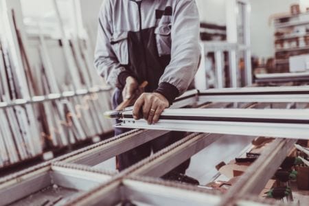 A man sanding the edges of a window