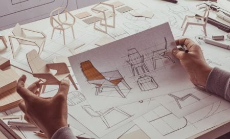 A man looking at the sketch of a chair