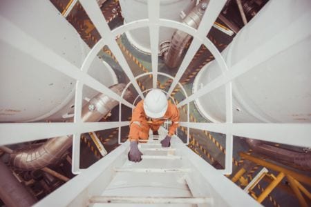 A gas network craftperson climbing a ladder