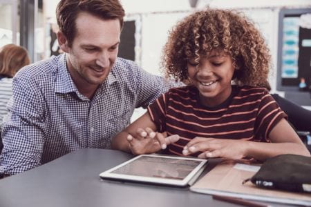 A man and a girl looking at a tablet smiling