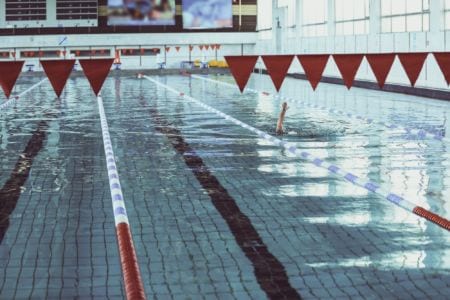 A person swimming in a pool indoors