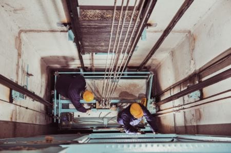 Two workers fixing an escalator