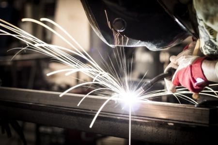 A worker with protective mask welding metal