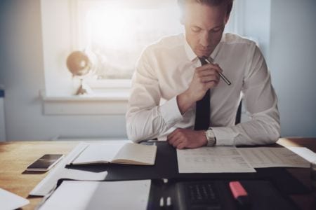 A man sitting and looking at documents on a table