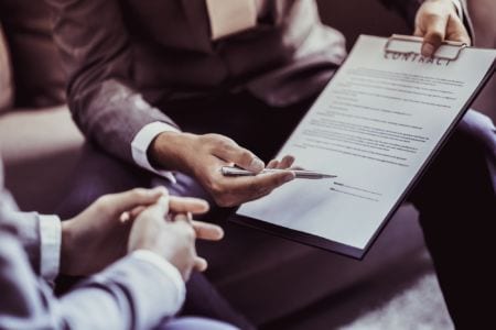 Policy officer holding a contract in front of a client