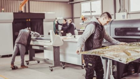 Group of printmaker technician operators working on a digital printing press