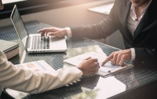 Business people negotiating a contract and pointing to a document