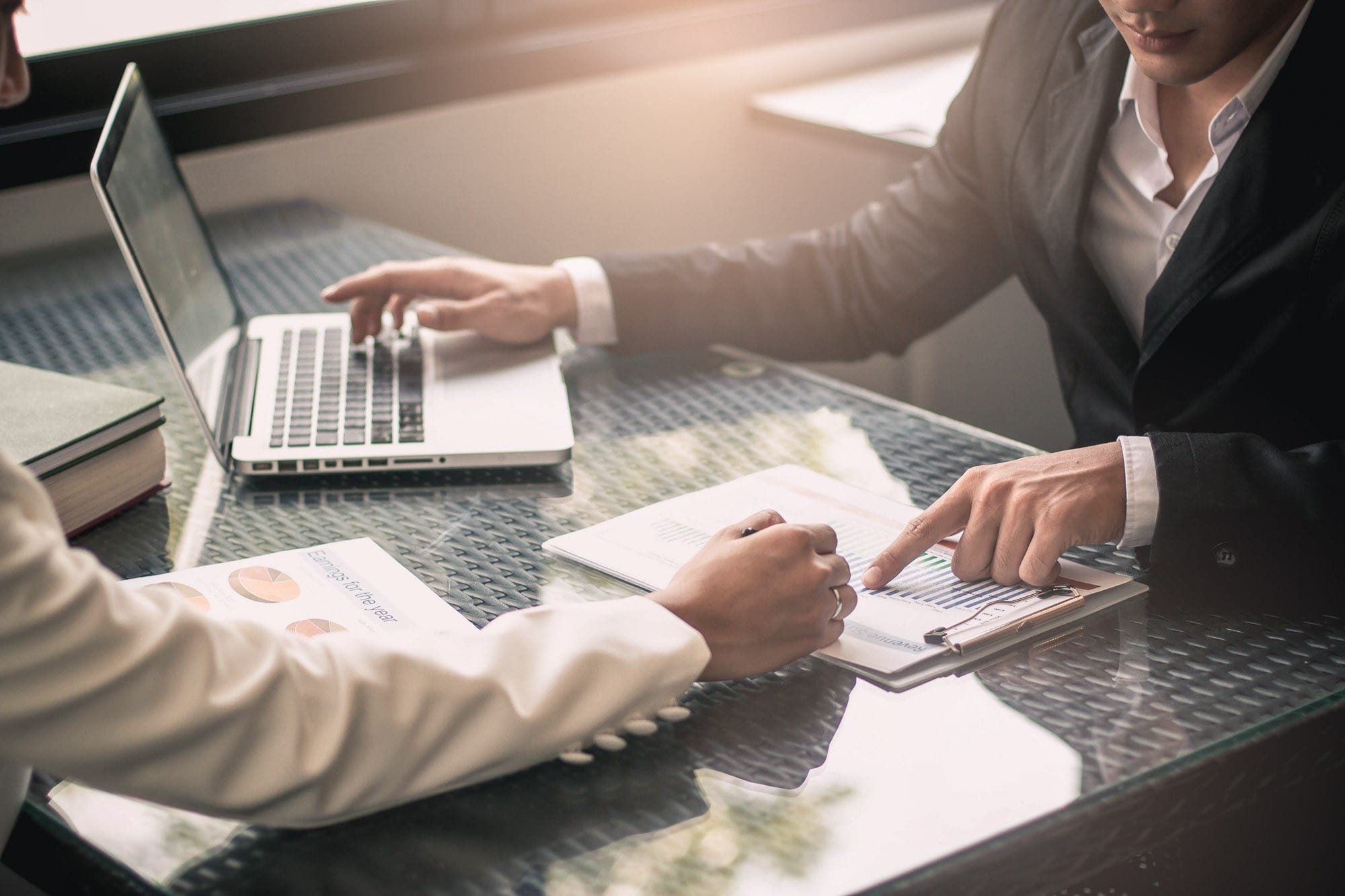 Business people negotiating a contract and pointing to a document