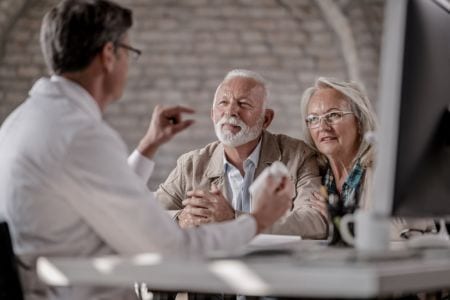Senior financial services customer adviser talking to an elderly couple