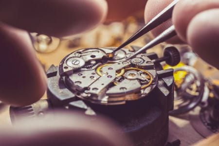 A close up of a watchmaker repairing a vintage watch