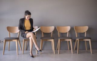 Apprenticeship commitment statements woman sitting in a chair reading a document while waiting for a job interview in the waiting room