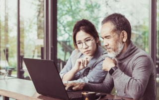 Father and daughter looking at a laptop