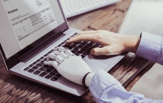 A person with a prosthetic hand working on a laptop