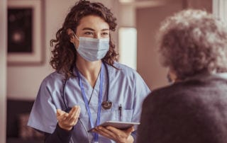 Apprentice nurse talking to female patient