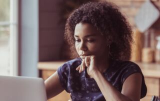 Woman sitting in front of a laptop looking worried